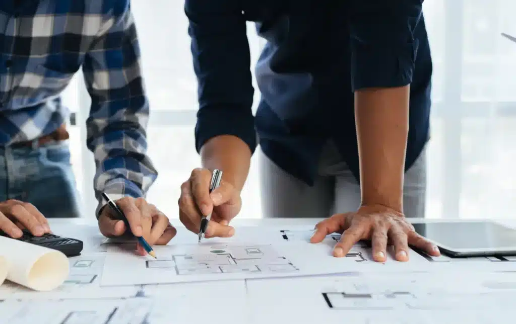 Two people drawing blueprint for building