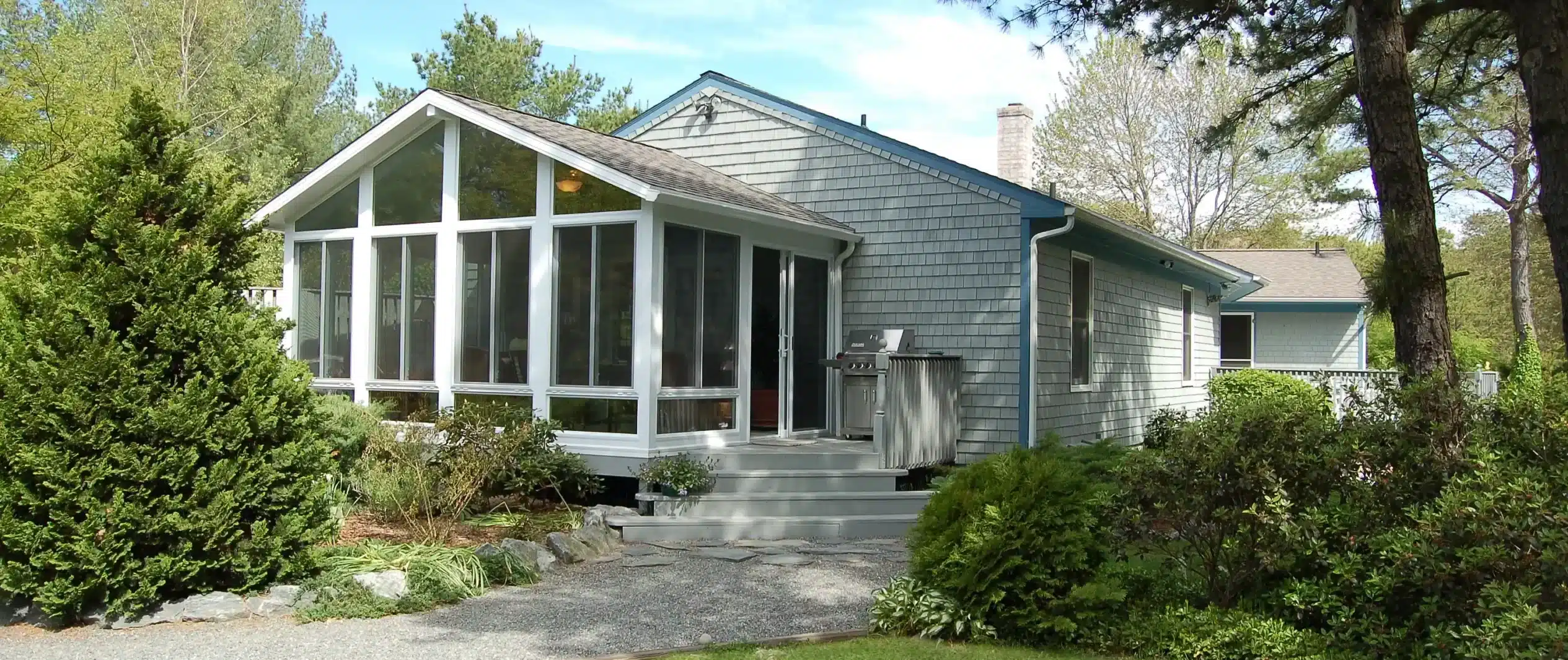 Newly built sunroom attached to home next to grill
