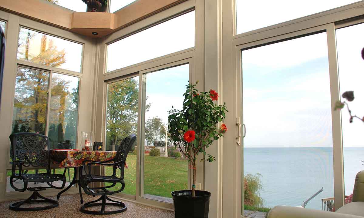 White sunroom with indoor plant and lakeview
